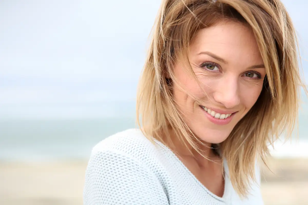 beautiful middle-aged woman smiling at the beach