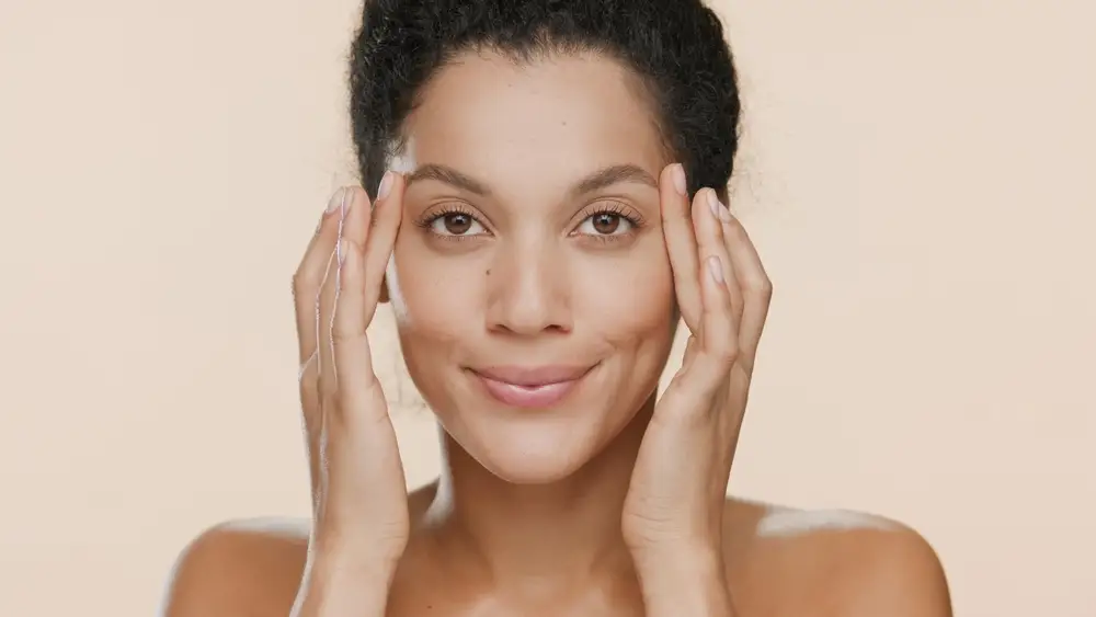 woman holding her skin up to prevent baggy eyes
