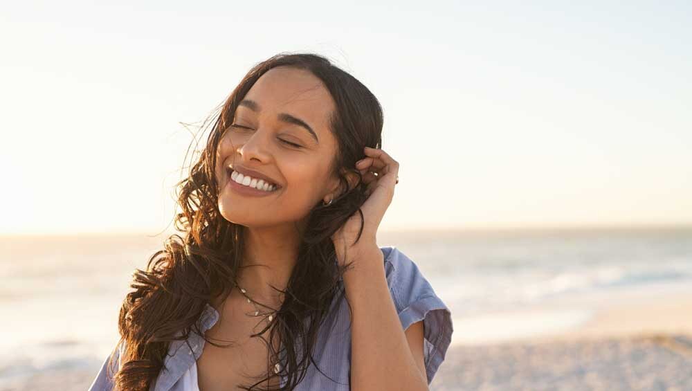 young woman smiling at the beach